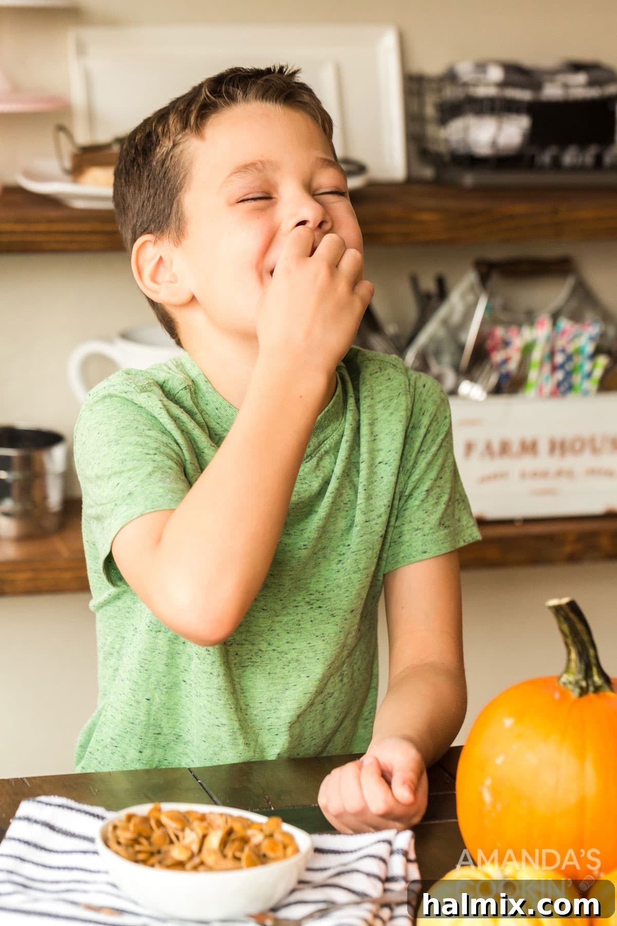 A happy child enjoying a handful of freshly roasted pumpkin seeds, a healthy and delicious snack.