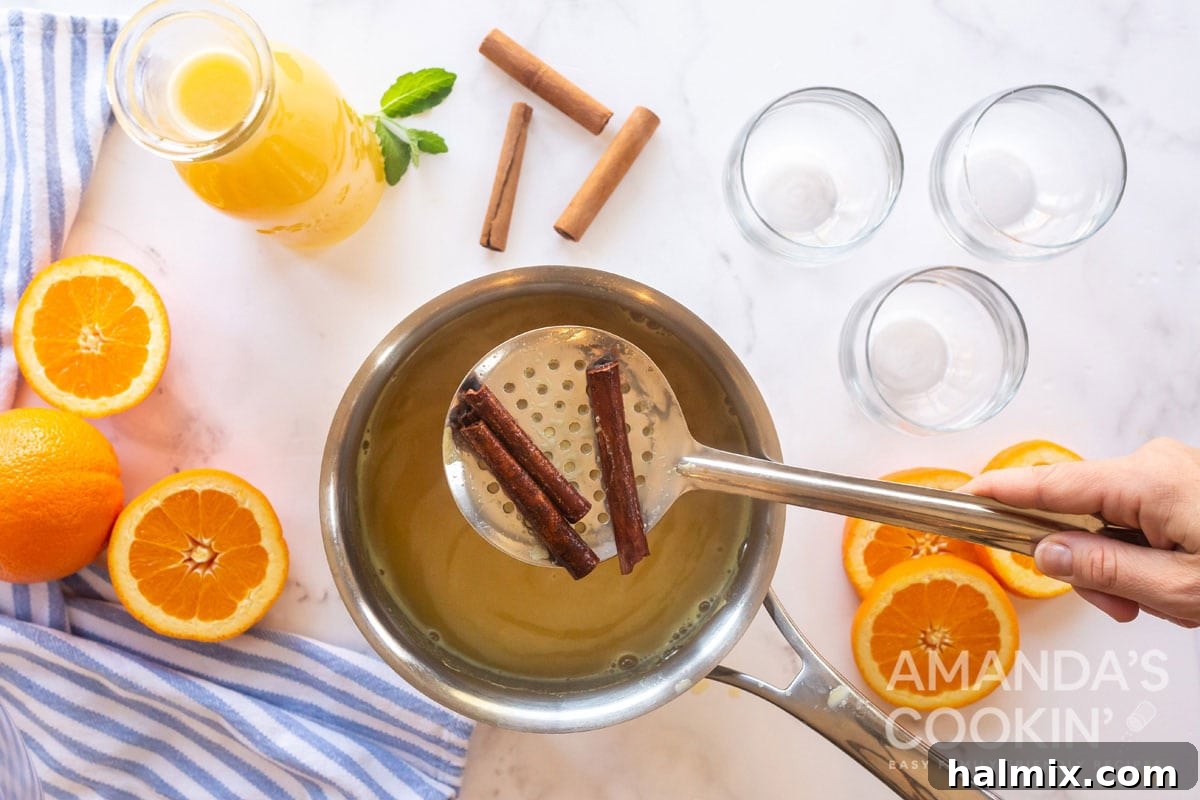 straining cinnamon sticks from saucepan