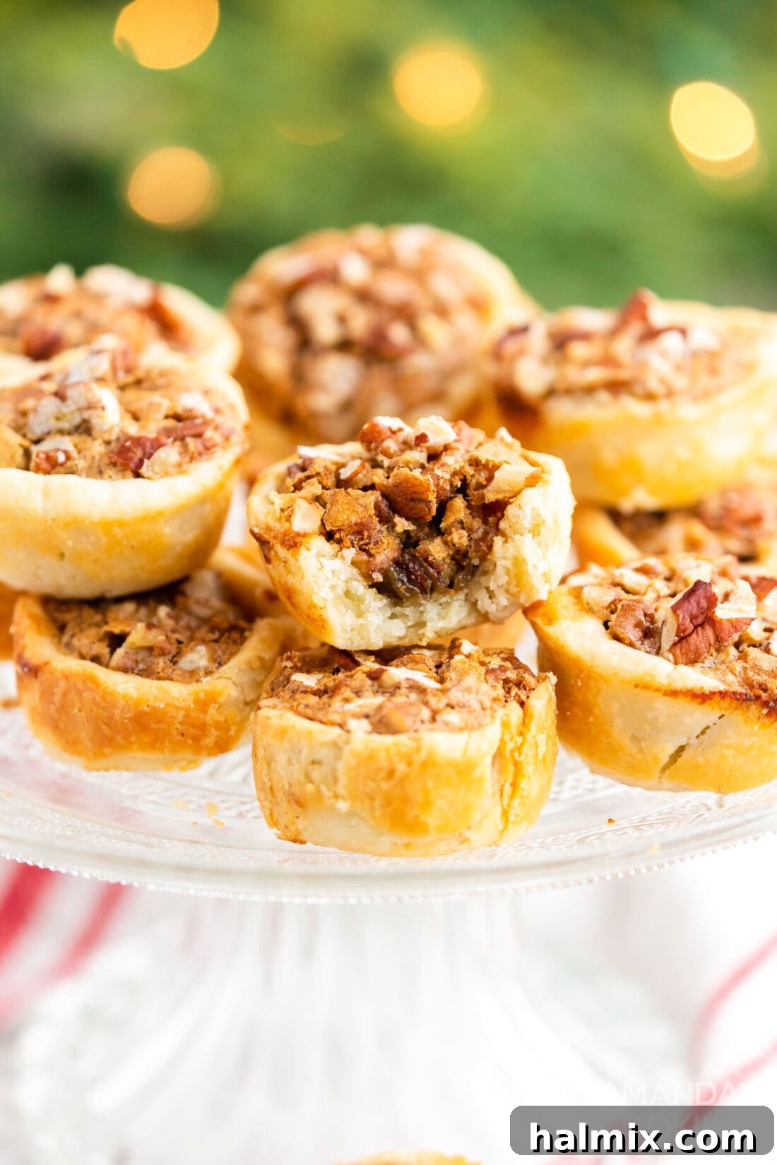 A pecan tassie with a small bite taken out, revealing the rich, gooey pecan filling and flaky crust.