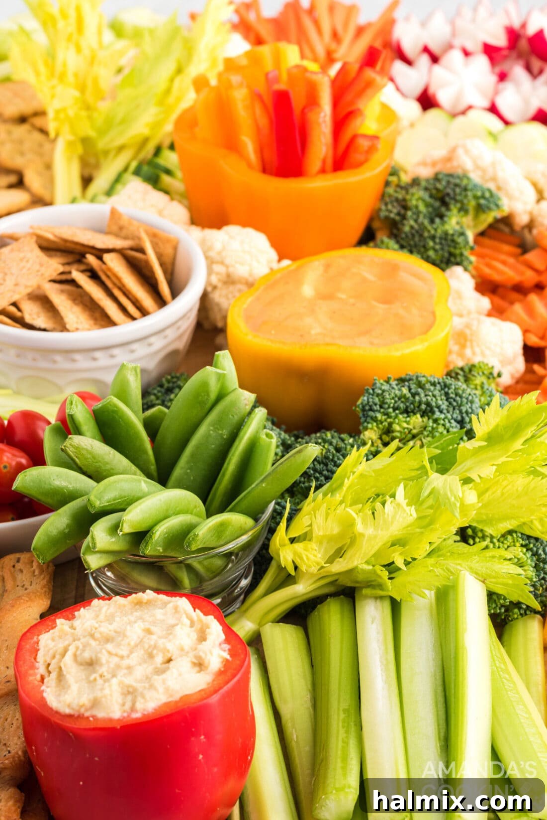 Edible Sculptures: Crafting Decorative Vegetables 13 A large, beautifully arranged display of various cut vegetables, including striped cucumbers, julienned carrots, and bell pepper strips, on a serving board with dips.