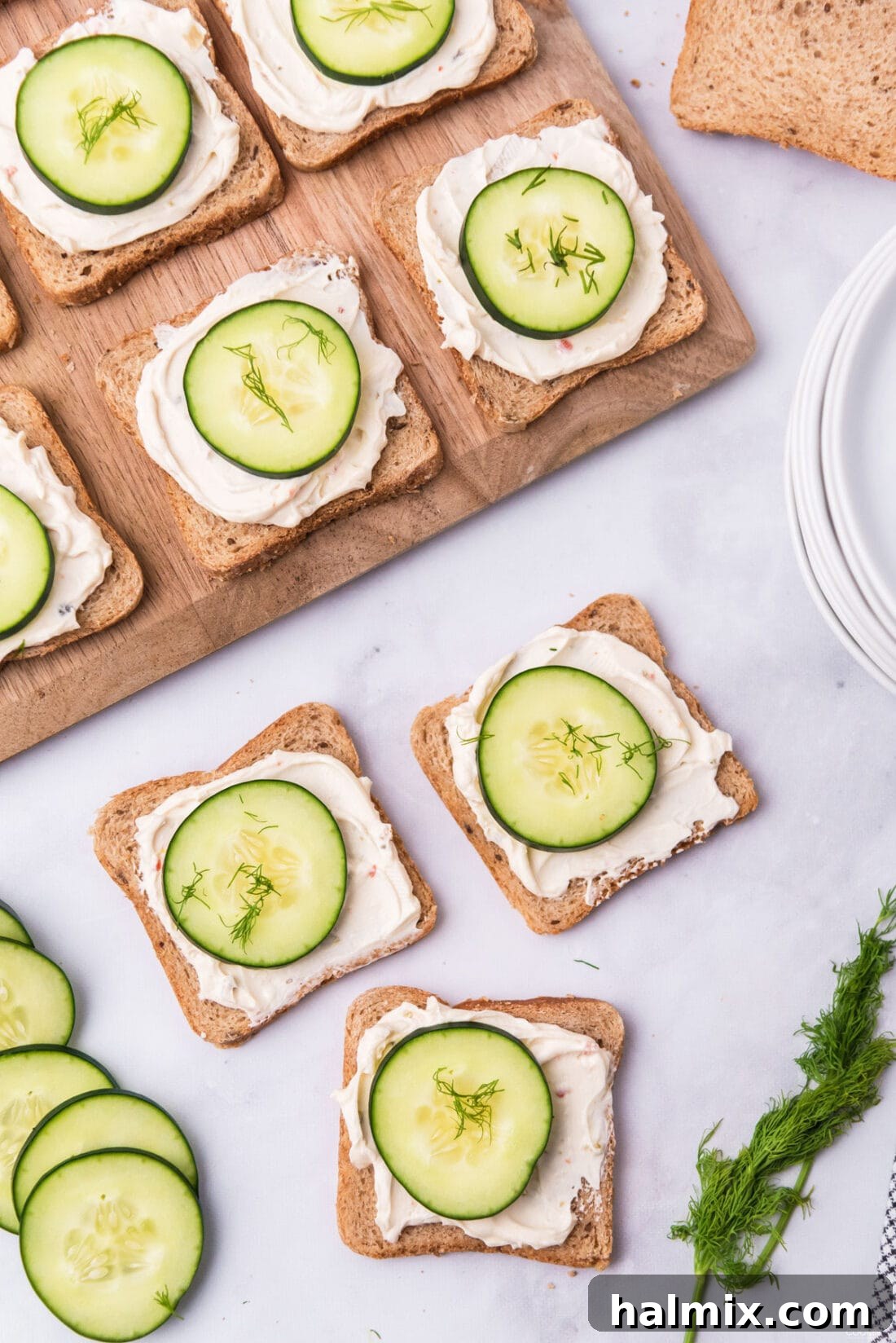 Refreshing Cucumber Finger Sandwiches 2 Delightful mini cucumber sandwiches artfully arranged on a rustic wood board, ready to be served as an elegant appetizer.
