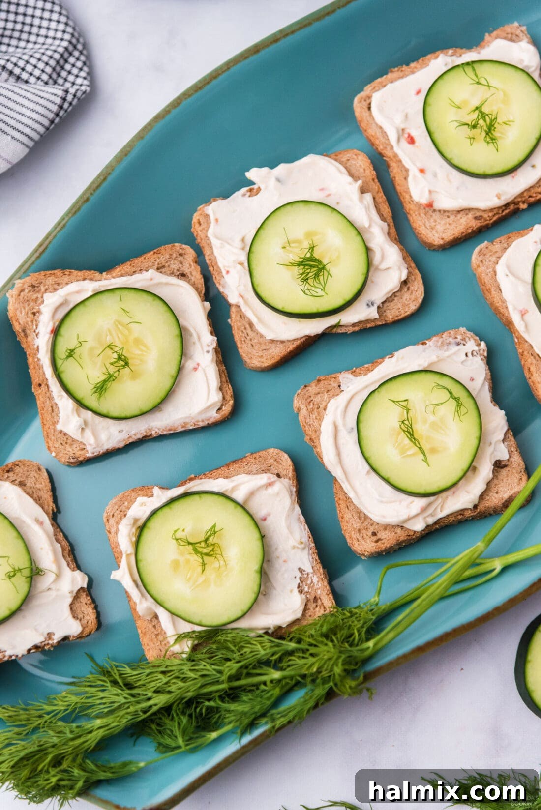 Refreshing Cucumber Finger Sandwiches 3 An array of fresh cucumber sandwiches arranged neatly on a vibrant blue platter, showcasing their simple beauty.