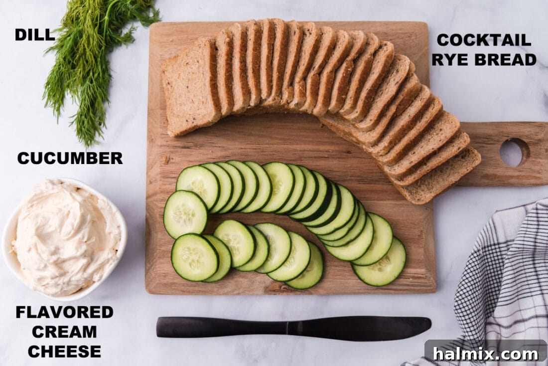 Refreshing Cucumber Finger Sandwiches 4 A selection of fresh ingredients laid out, including cocktail rye bread, a tub of cream cheese, a large cucumber, and a small container of dill, for making mini cucumber sandwiches.