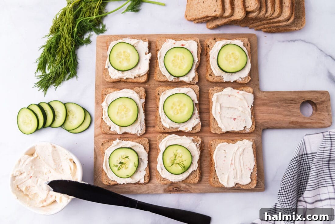 Refreshing Cucumber Finger Sandwiches 6 A series of mini cucumber sandwiches being assembled, showing cream cheese being spread on bread, cucumber slices being placed, and a final sprinkle of dill.