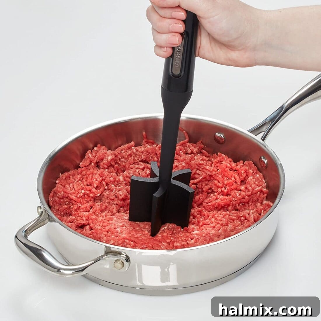 21 Clever Kitchen Gadgets You'll Use Constantly 15 Mashing ground beef in a skillet with a meat/potato masher, illustrating its effectiveness for breaking up meat.