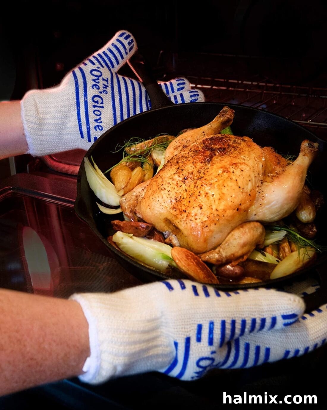 21 Clever Kitchen Gadgets You'll Use Constantly 18 A hand wearing an Ove Glove safely removing a hot chicken from the oven, emphasizing heat resistance and flexibility.