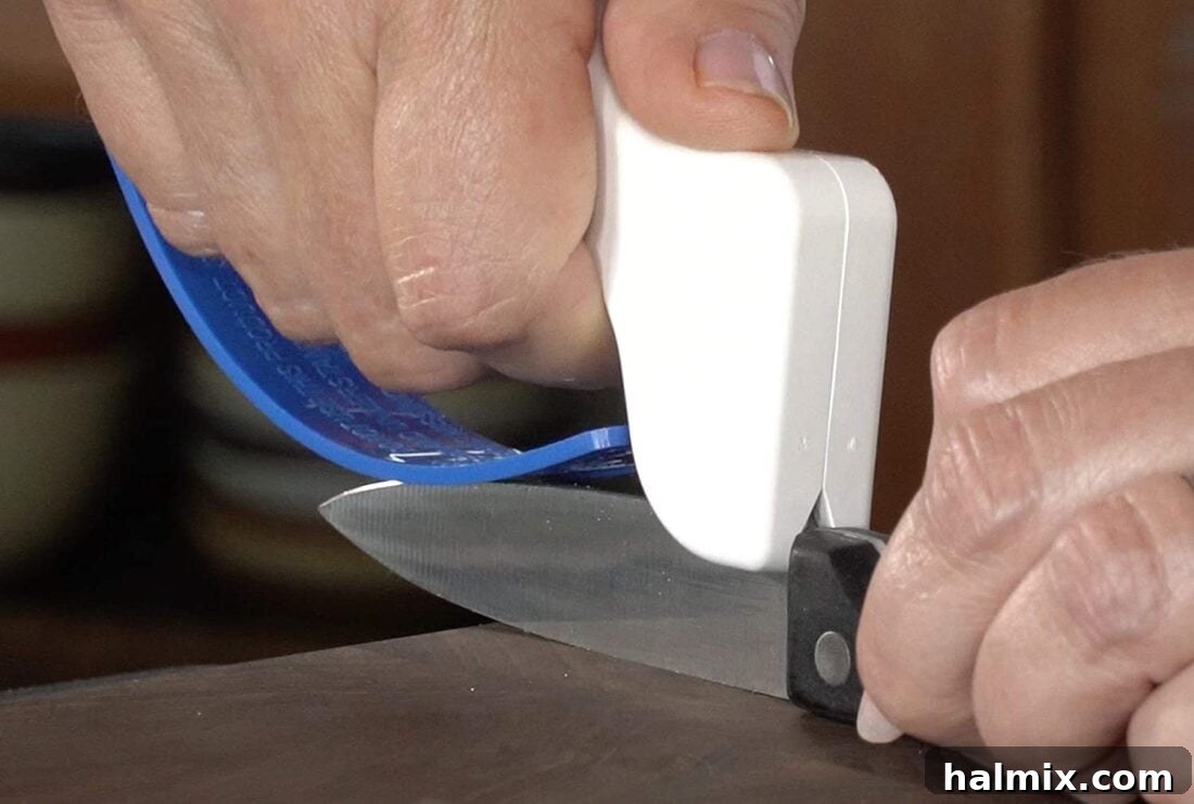 21 Clever Kitchen Gadgets You'll Use Constantly 3 Sharpening a kitchen knife with an ergonomic knife sharpener, highlighting safety and ease of use.
