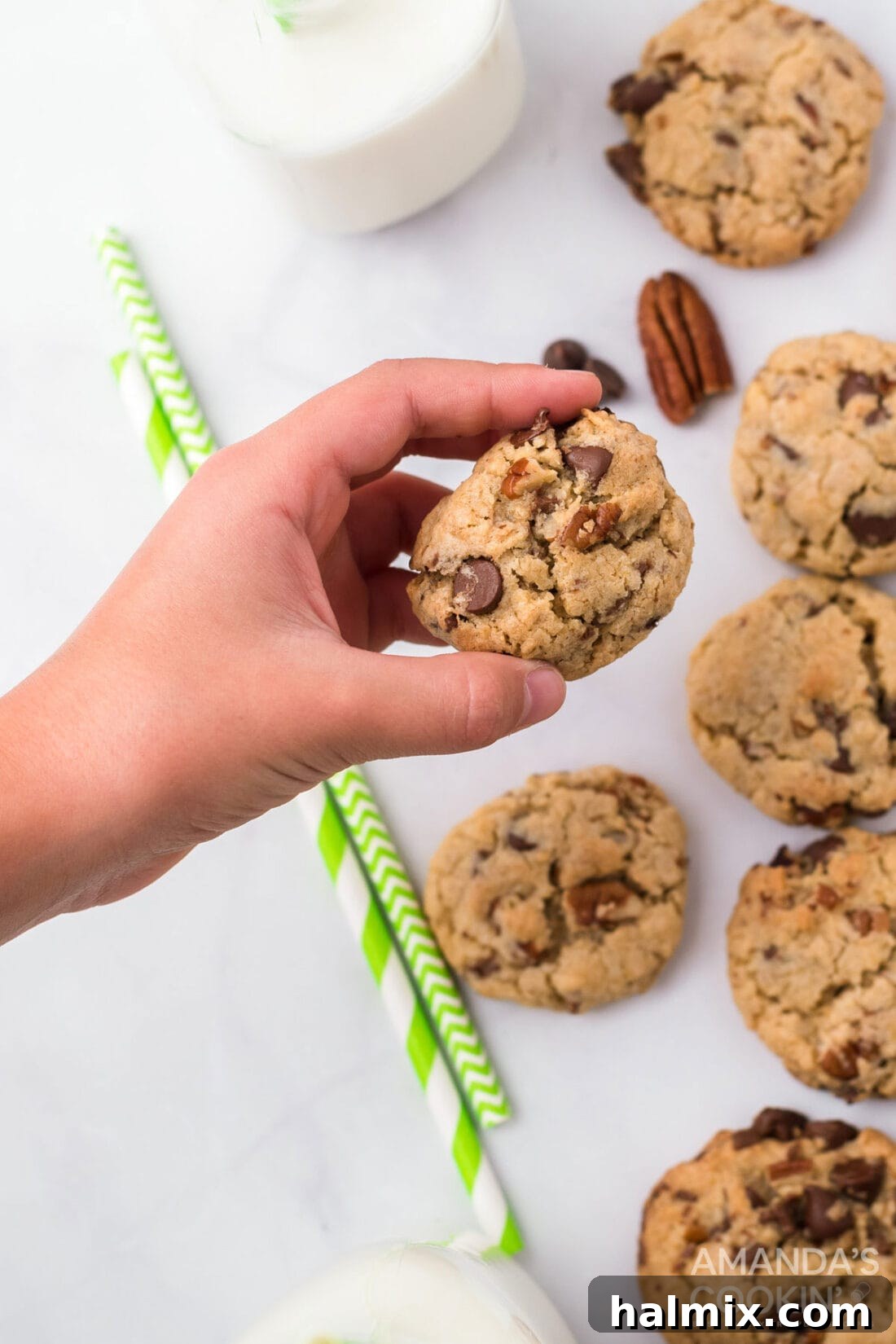 A hand holding a perfectly baked Neiman Marcus cookie, showcasing its rich texture and chocolate chunks.