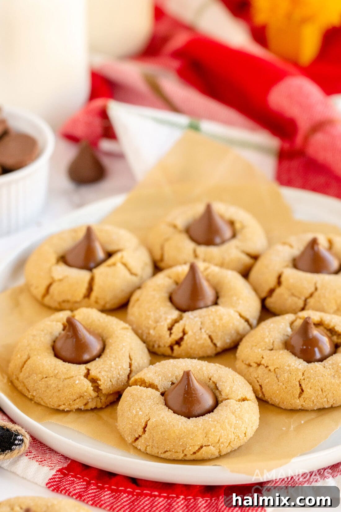 Close-up view of freshly baked Peanut Butter Blossoms on a plate, showcasing their soft texture and melted Hershey's Kisses.