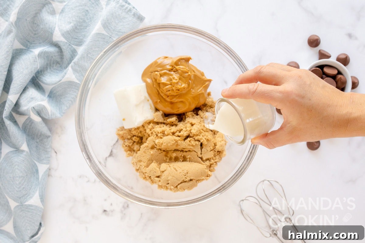 Mixing shortening, peanut butter, brown sugar, milk, and vanilla in a large bowl with a spoon.