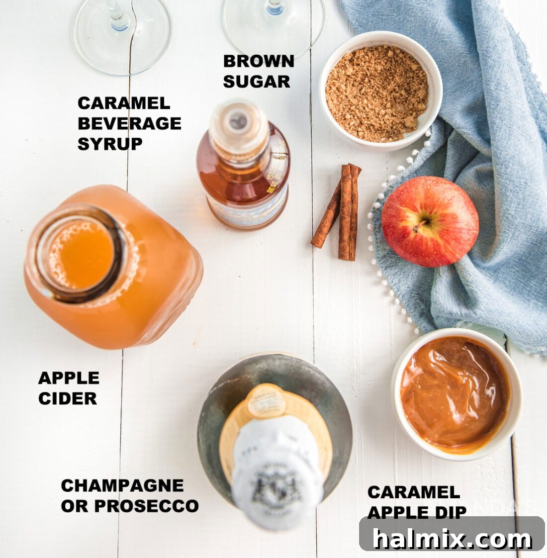 Labeled ingredients for caramel apple mimosas, including champagne, apple cider, cinnamon, brown sugar, caramel dip, and caramel syrup.