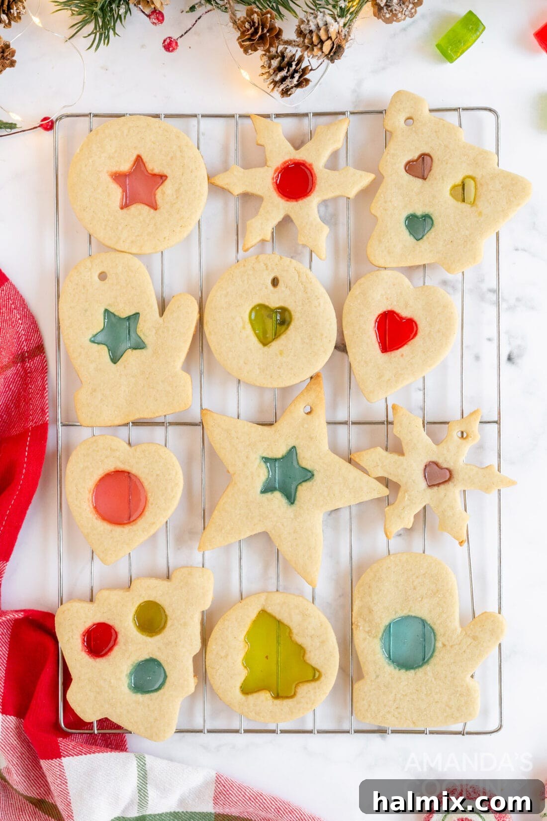 Close-up view of various stained glass cookies, with different shapes and colors, arranged on a cooling rack.