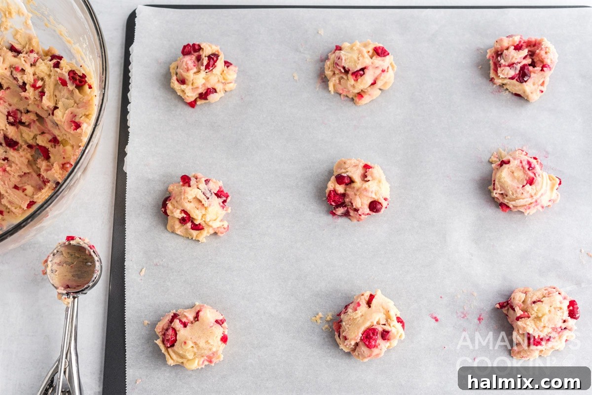 Evenly spaced White Chocolate Cranberry Cookie dough balls on a baking sheet.
