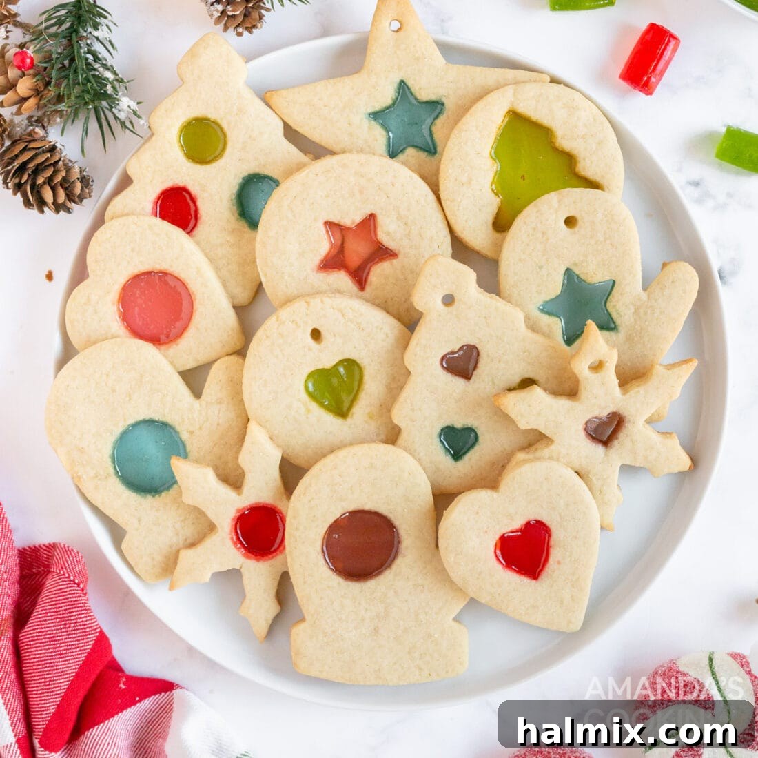 A plate showcasing an array of festive stained glass cookies, featuring vibrant, translucent candy centers that beautifully resemble stained glass.