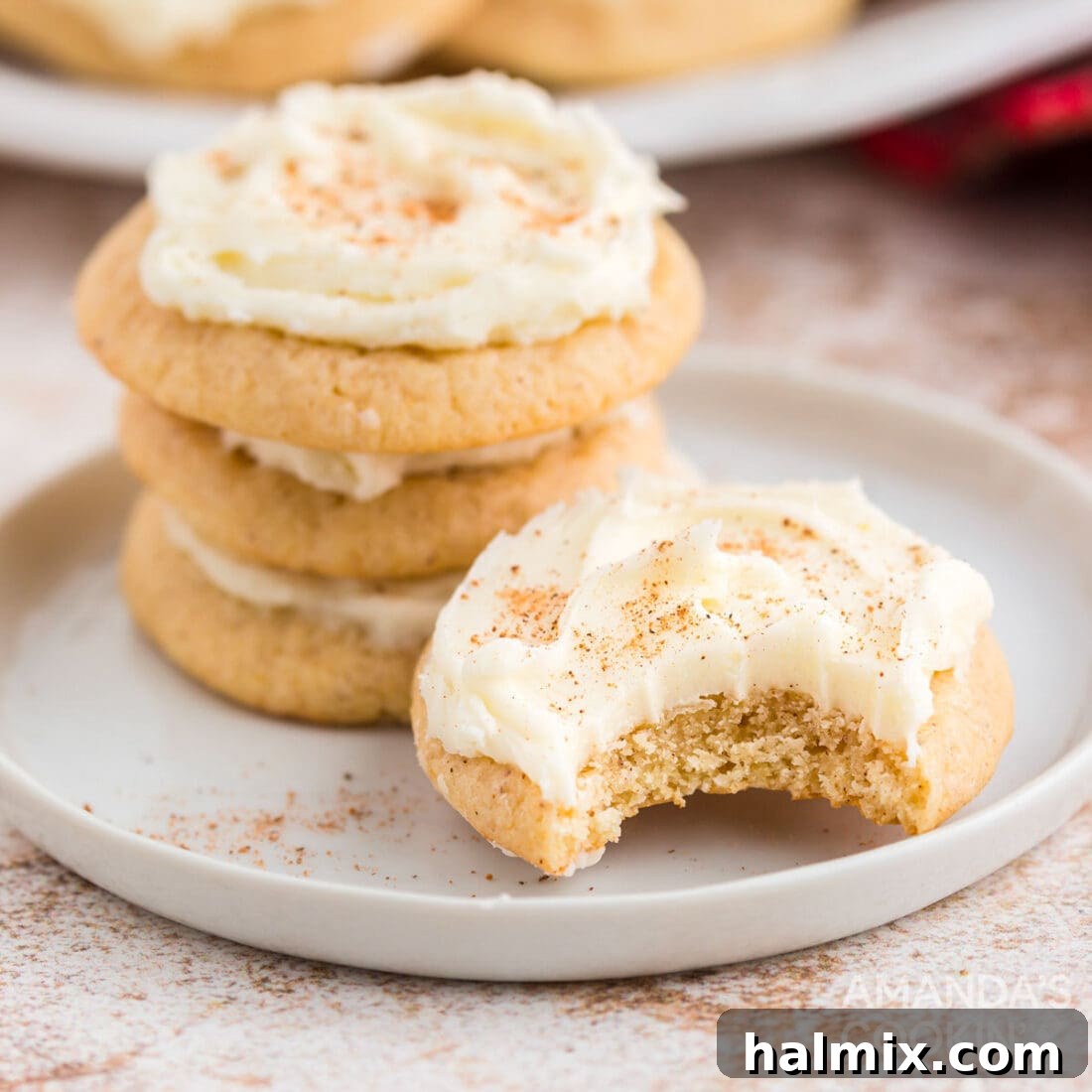 Frosted eggnog cookies elegantly arranged on a festive plate, lightly dusted with nutmeg, perfectly capturing the essence of holiday cheer.