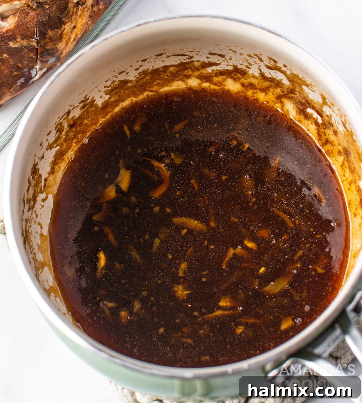 Ham glaze simmering in a saucepan, reducing to a thick syrup