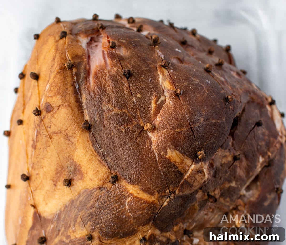 Close-up of ham scored with diamond pattern and cloves inserted at each intersection
