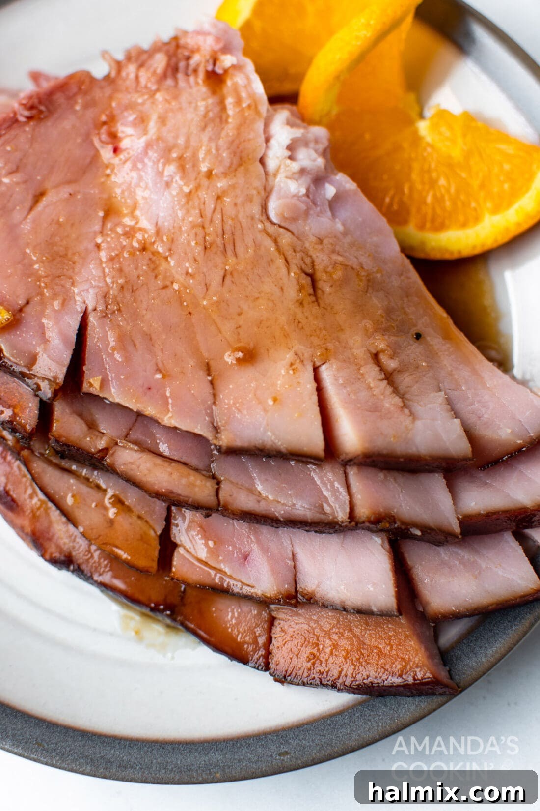 Beautifully sliced orange bourbon glazed ham presented on a serving platter