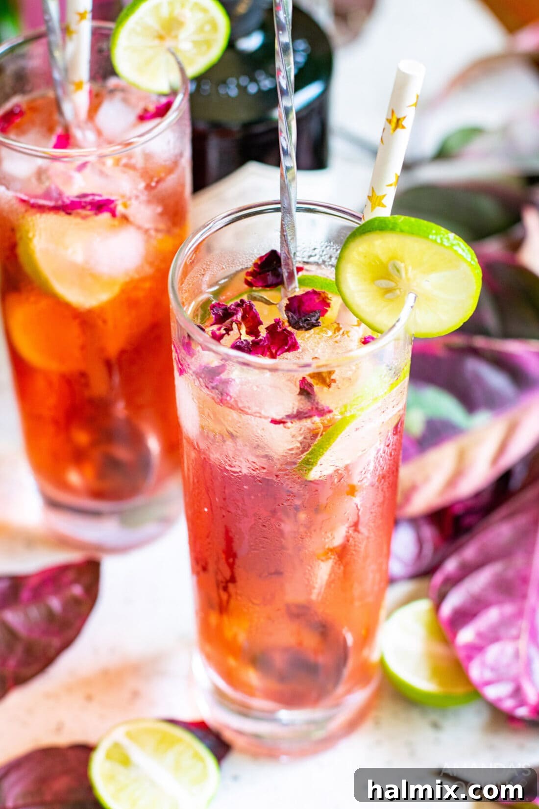 Blush Gin Tonic 2 Overhead shot of a Pink Gin & Tonic garnished with lime and delicate rose petals, ready to be enjoyed.