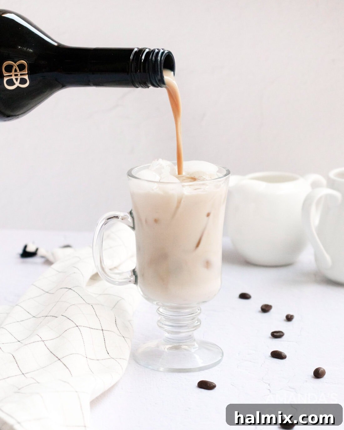 pouring baileys into a white russian