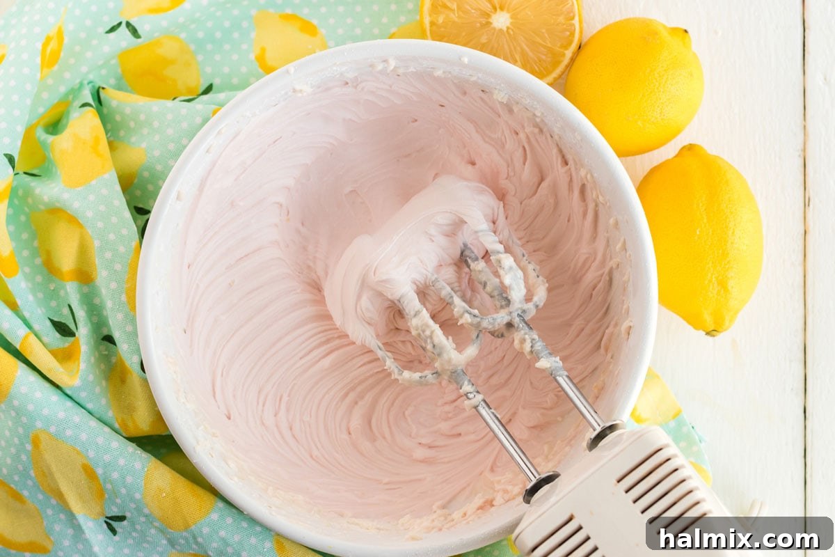 Mixing pink frosting in a bowl until creamy and smooth