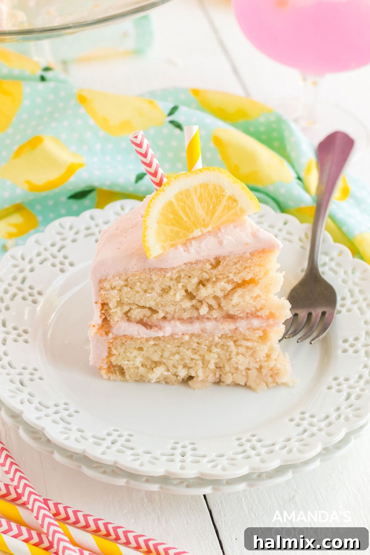 Slice of pink lemonade cake on a plate, ready to be enjoyed