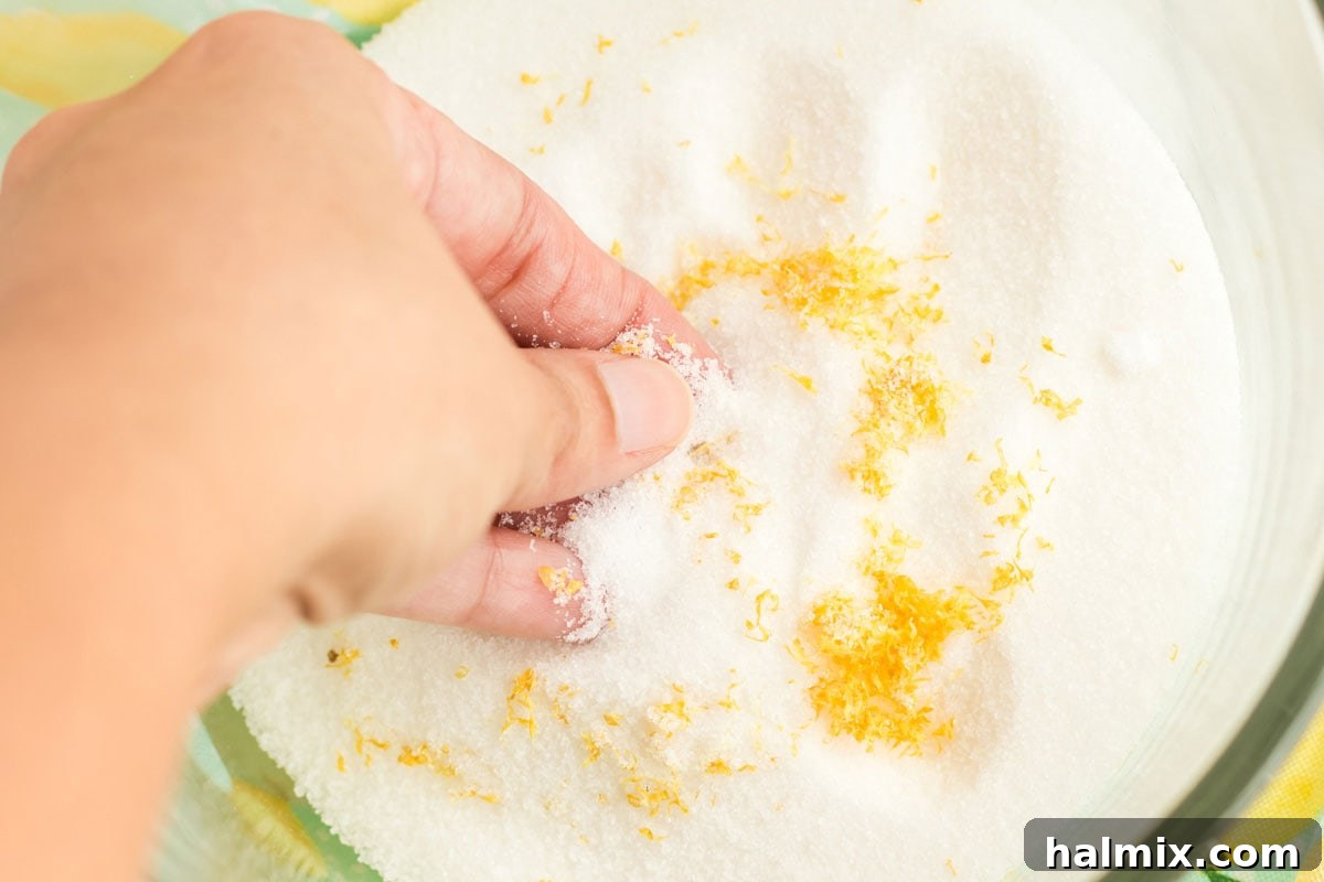 Rubbing fresh lemon zest into granulated sugar