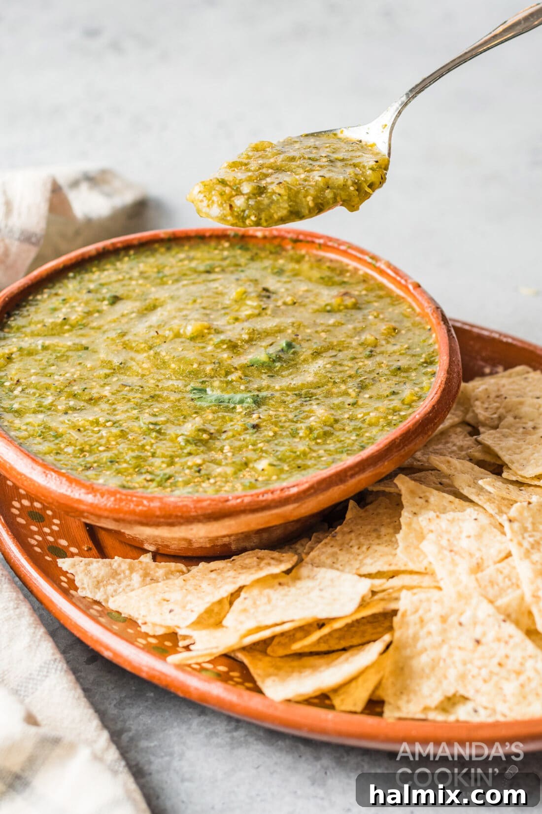 spoon lifting some salsa verde from bowl