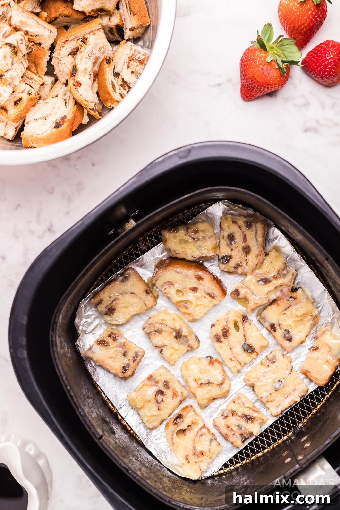 Perfectly arranged bread squares in a non-stick air fryer basket, ready for cooking into golden French toast bites.