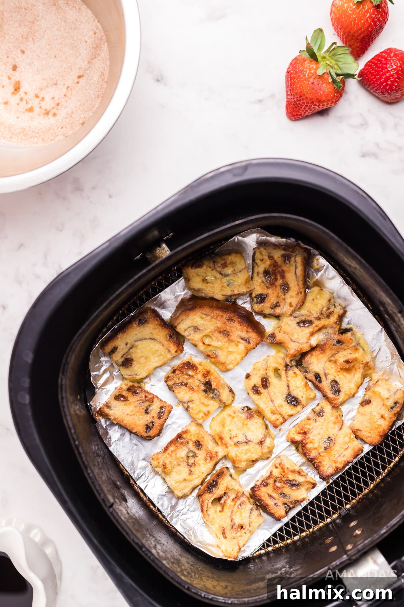Beautifully cooked Air Fryer French Toast Bites, golden and ready to be removed from the air fryer basket.