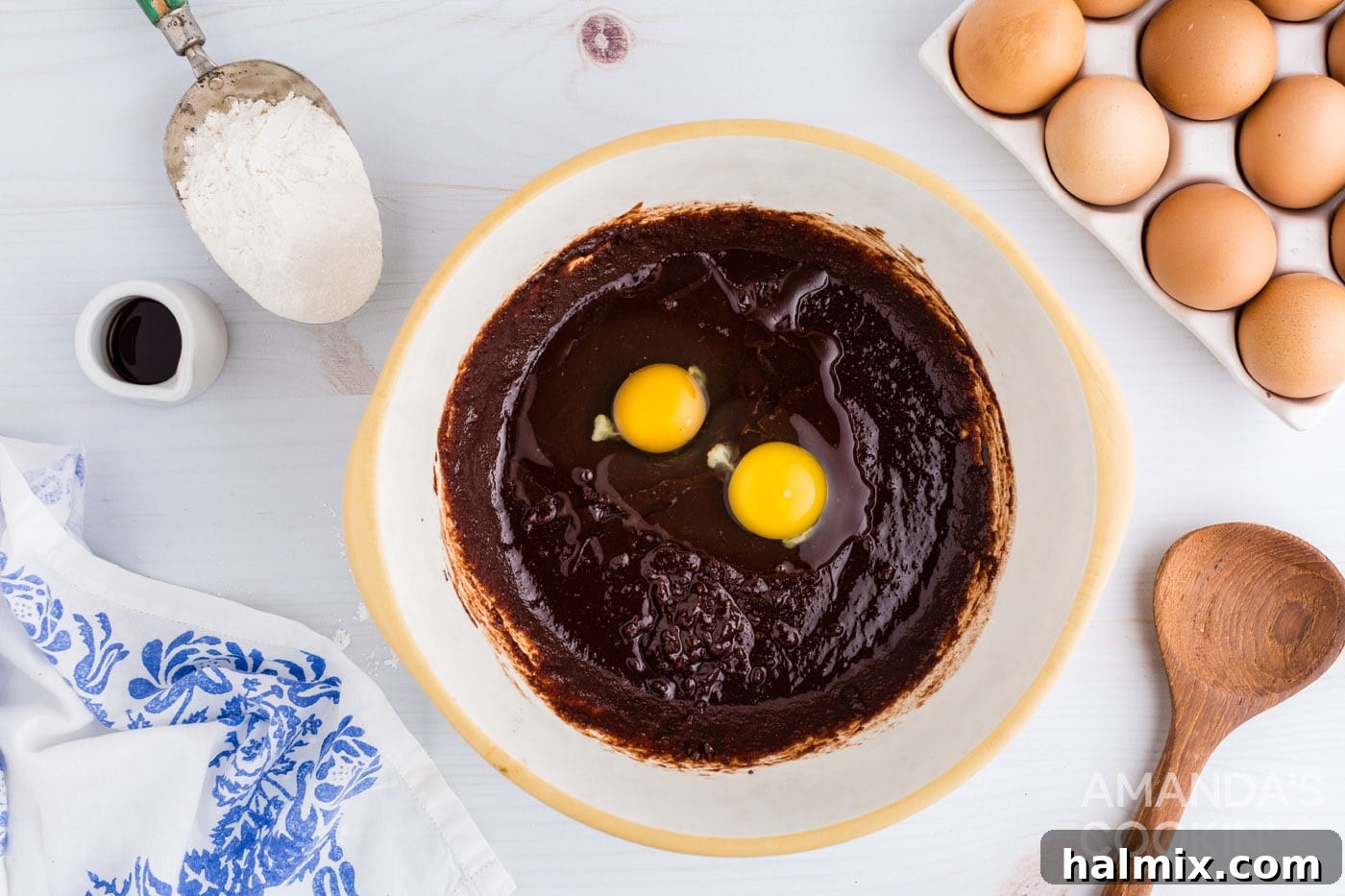 Adding eggs to brownie mixture in a bowl