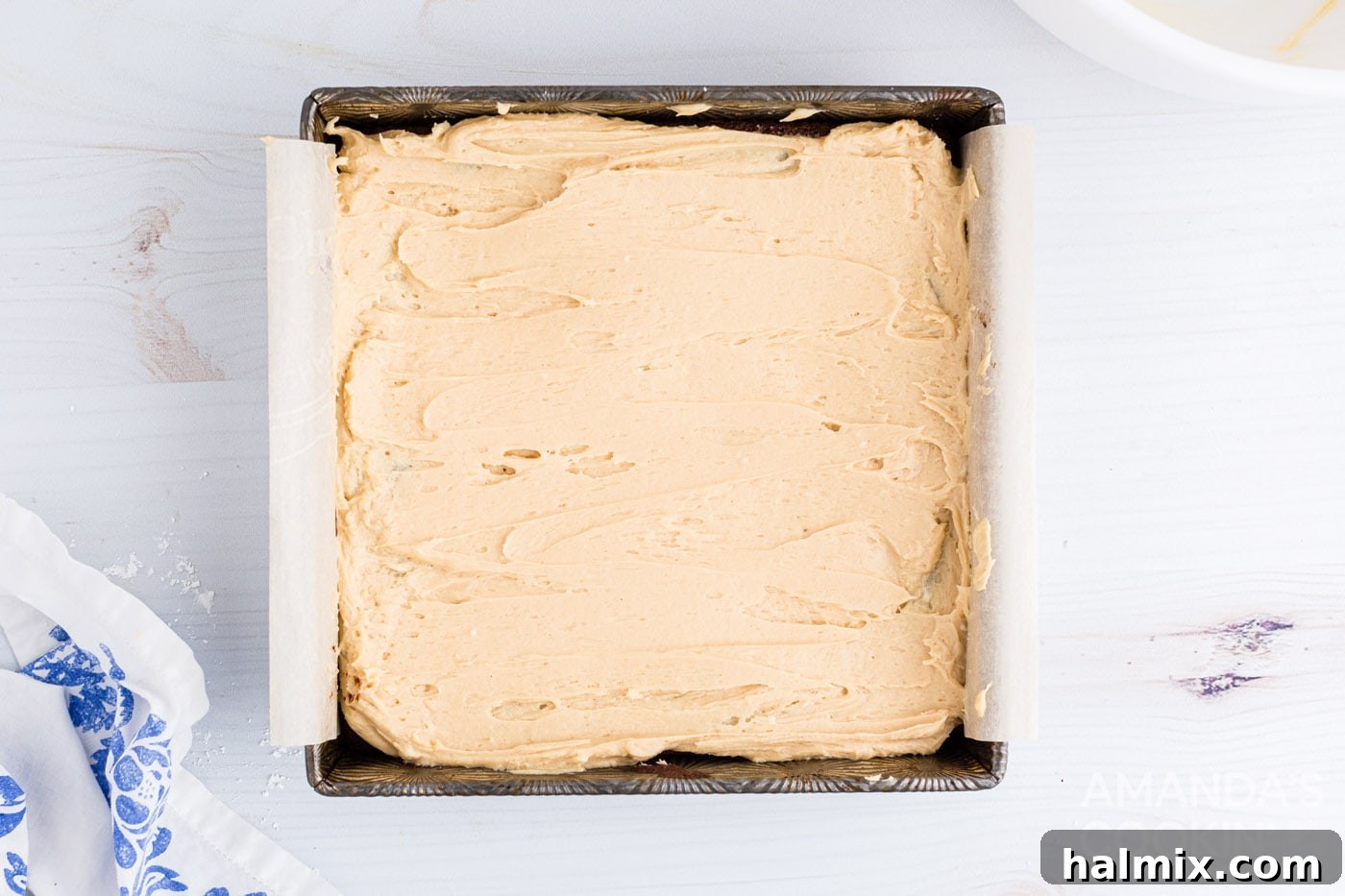 Creamy peanut butter frosting spread generously over fudge brownies