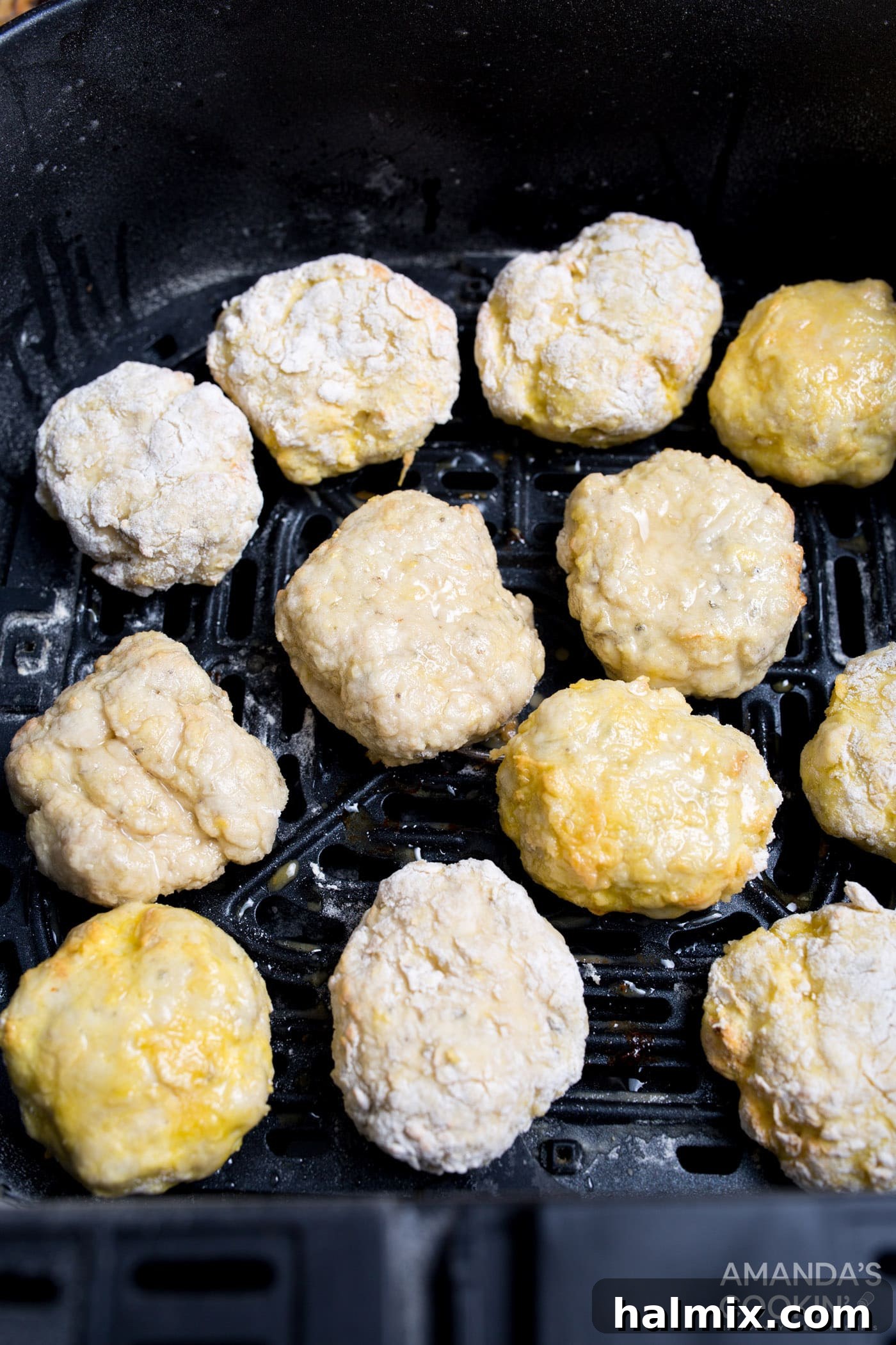 Several uncooked, breaded air fryer chicken nuggets neatly arranged in a single layer within an air fryer basket, ready for cooking.
