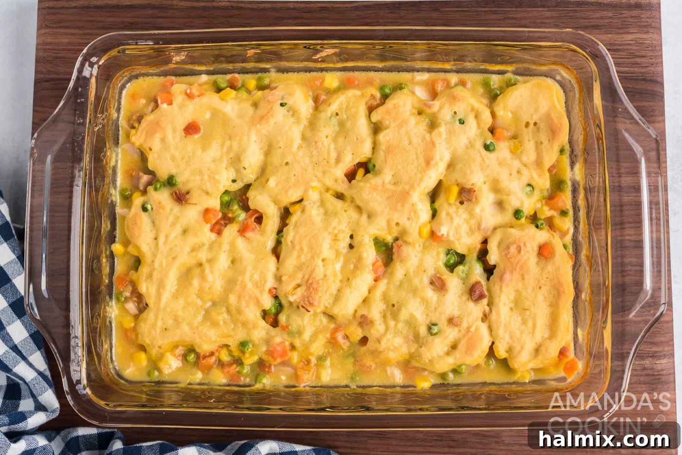 A freshly baked chicken and dumpling casserole with a golden, puffed top, just out of the oven.