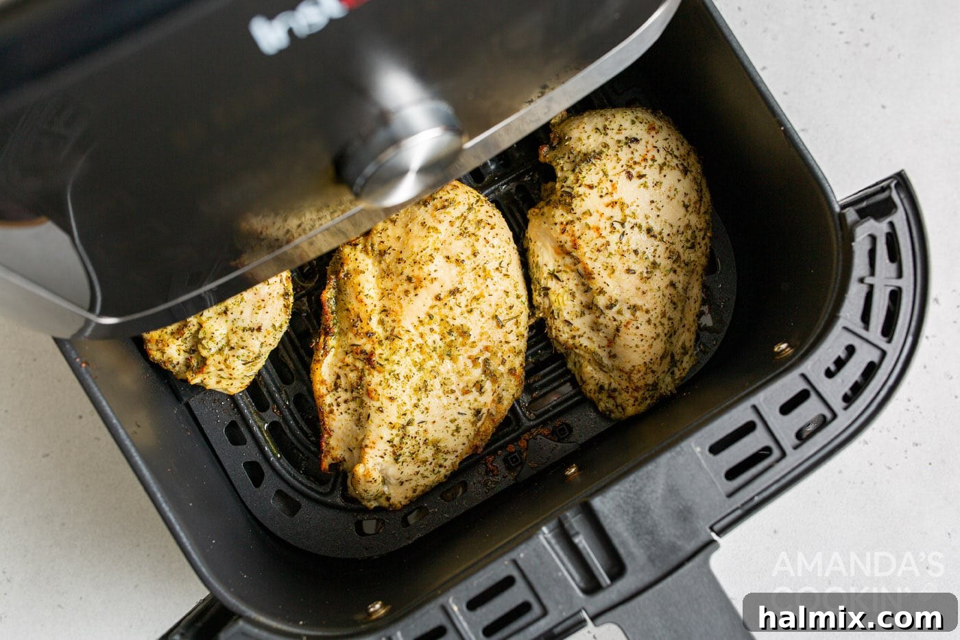 Cooked chicken breasts resting on a plate after air frying