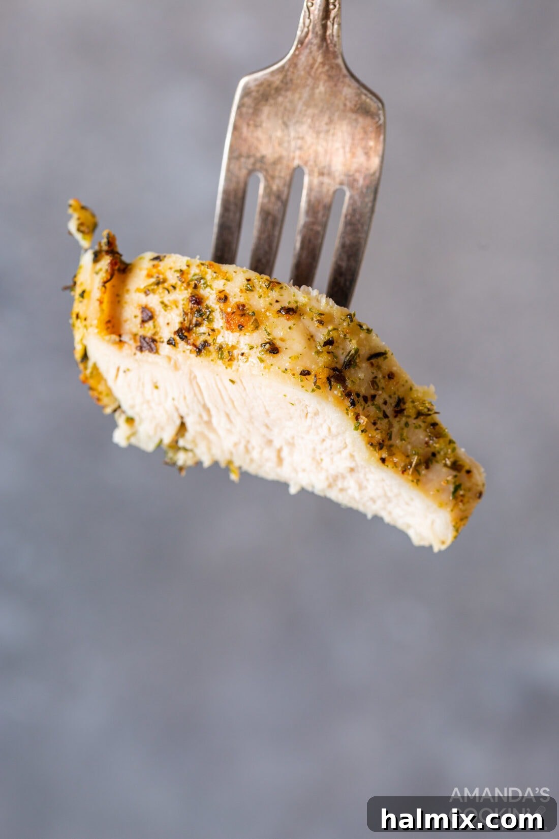 Fork lifting a piece of perfectly cooked air fryer chicken breast