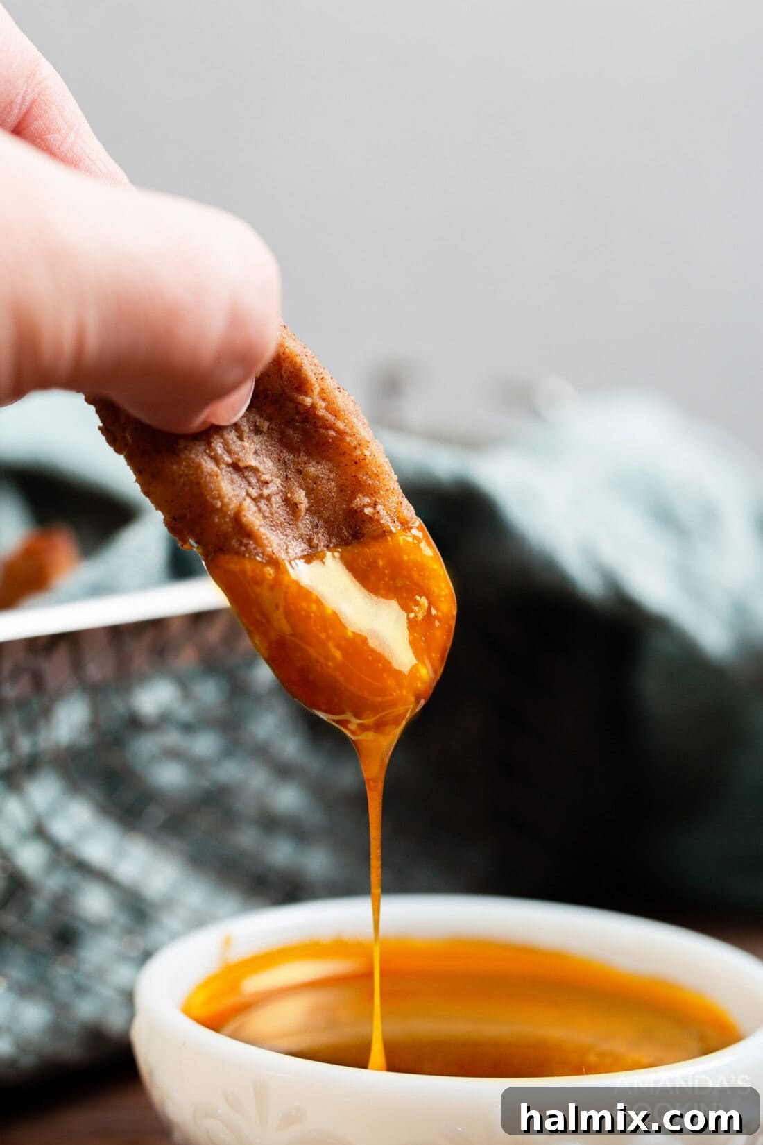 Crispy Air Fryer Apple Fries dipped in rich caramel sauce, an ultimate sweet treat.