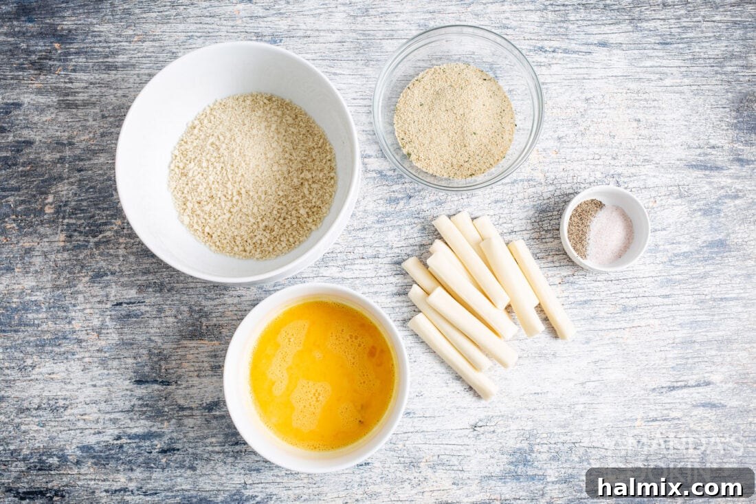 A collection of ingredients laid out, including eggs, string cheese, panko breadcrumbs, Italian breadcrumbs, salt, and pepper, ready for making air fryer mozzarella sticks.