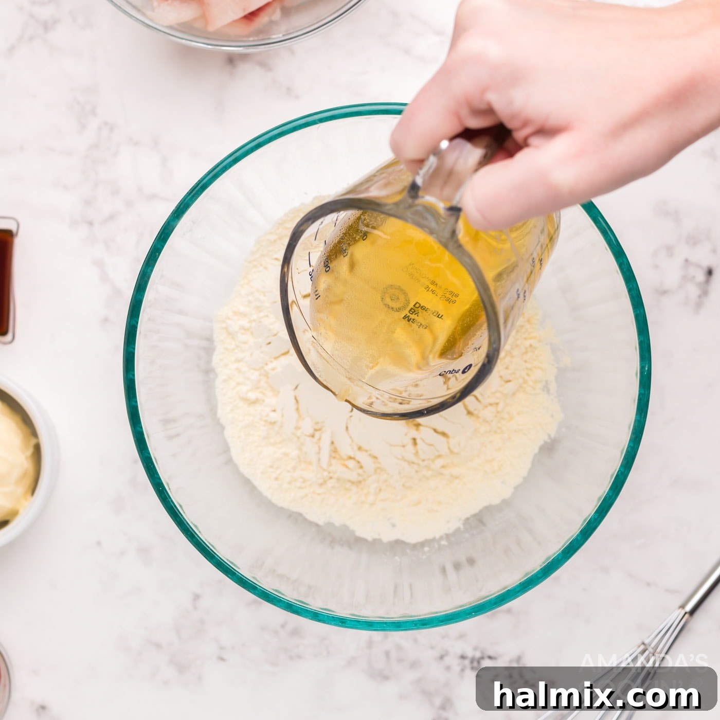 Beer being poured into a bowl of flour and seasonings for the fish batter.