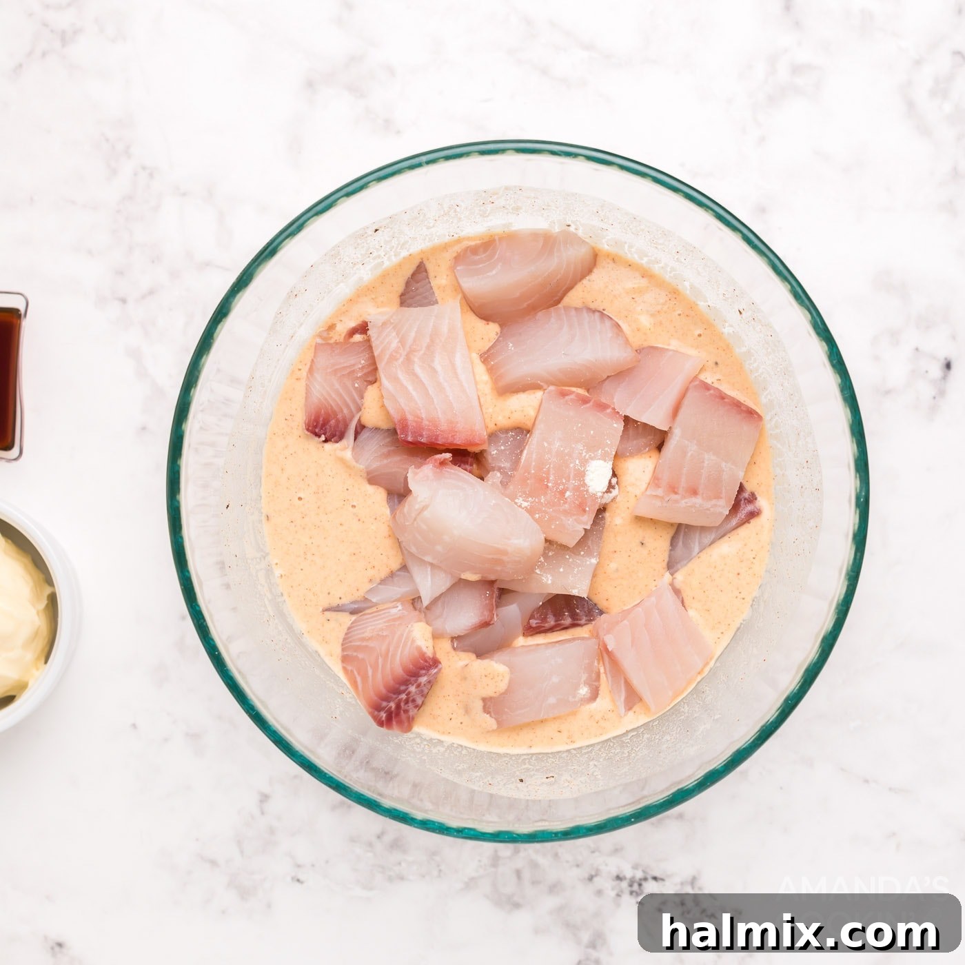 Fish nuggets fully coated in beer batter in a mixing bowl.