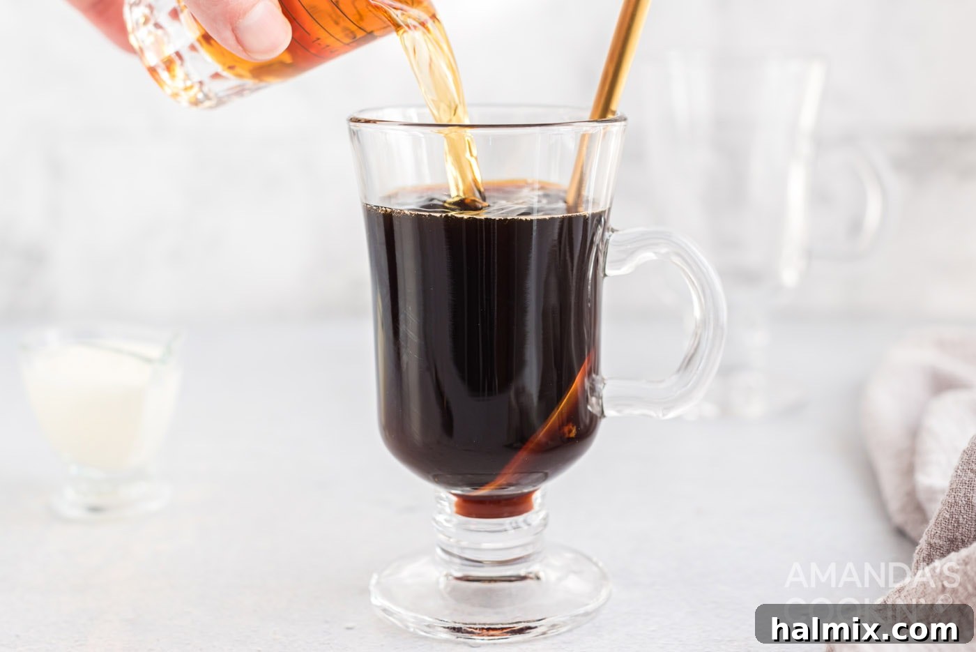 pouring Irish whiskey into mug of coffee