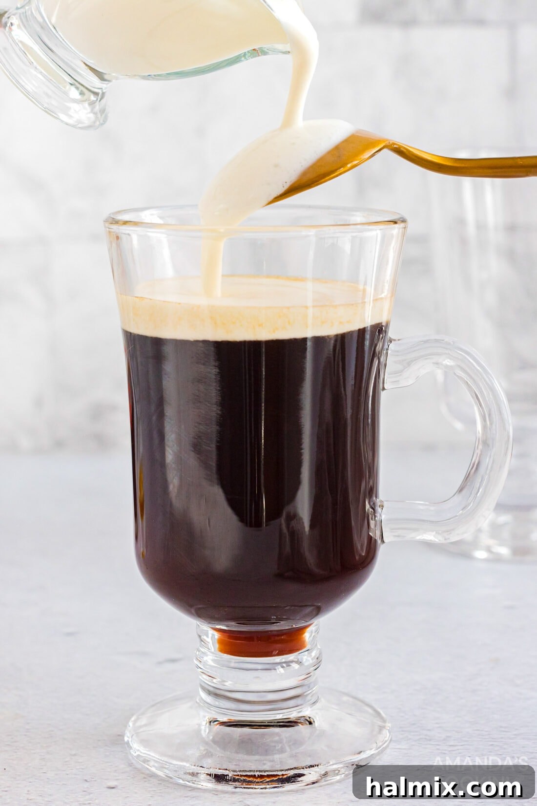pouring cream over back of spoon into Irish coffee