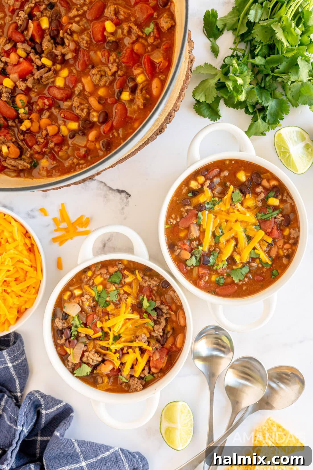 Two bowls of vibrant, hearty taco soup garnished with fresh cilantro and a dollop of sour cream, ready to be enjoyed.