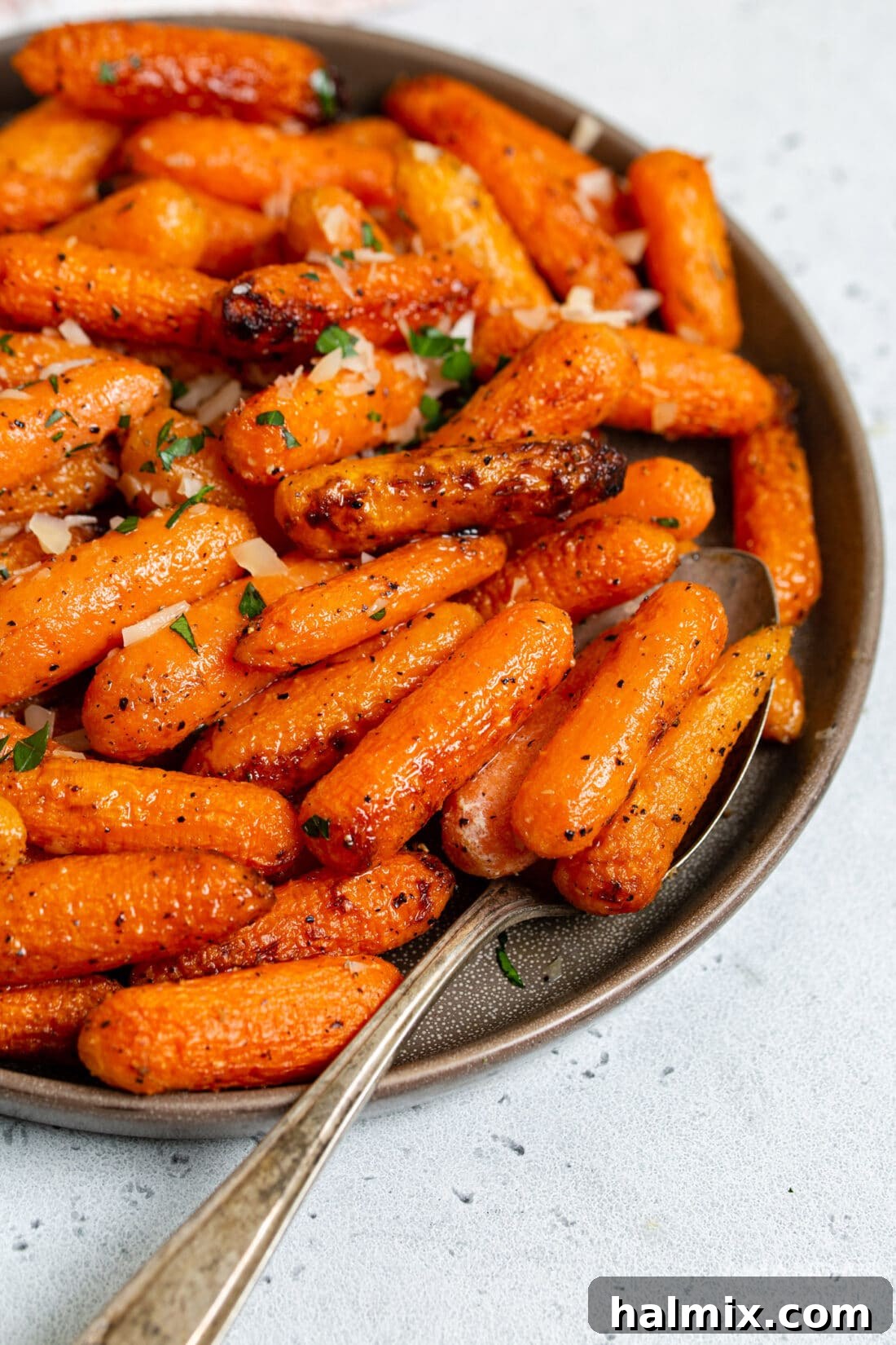 A close-up of a plate filled with perfectly roasted air fryer carrots, ready to be enjoyed as a side dish.
