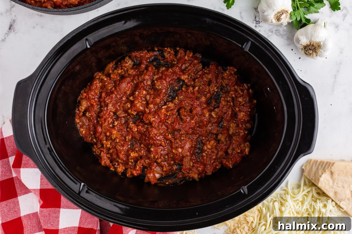 Meat sauce spread evenly at the bottom of a crockpot