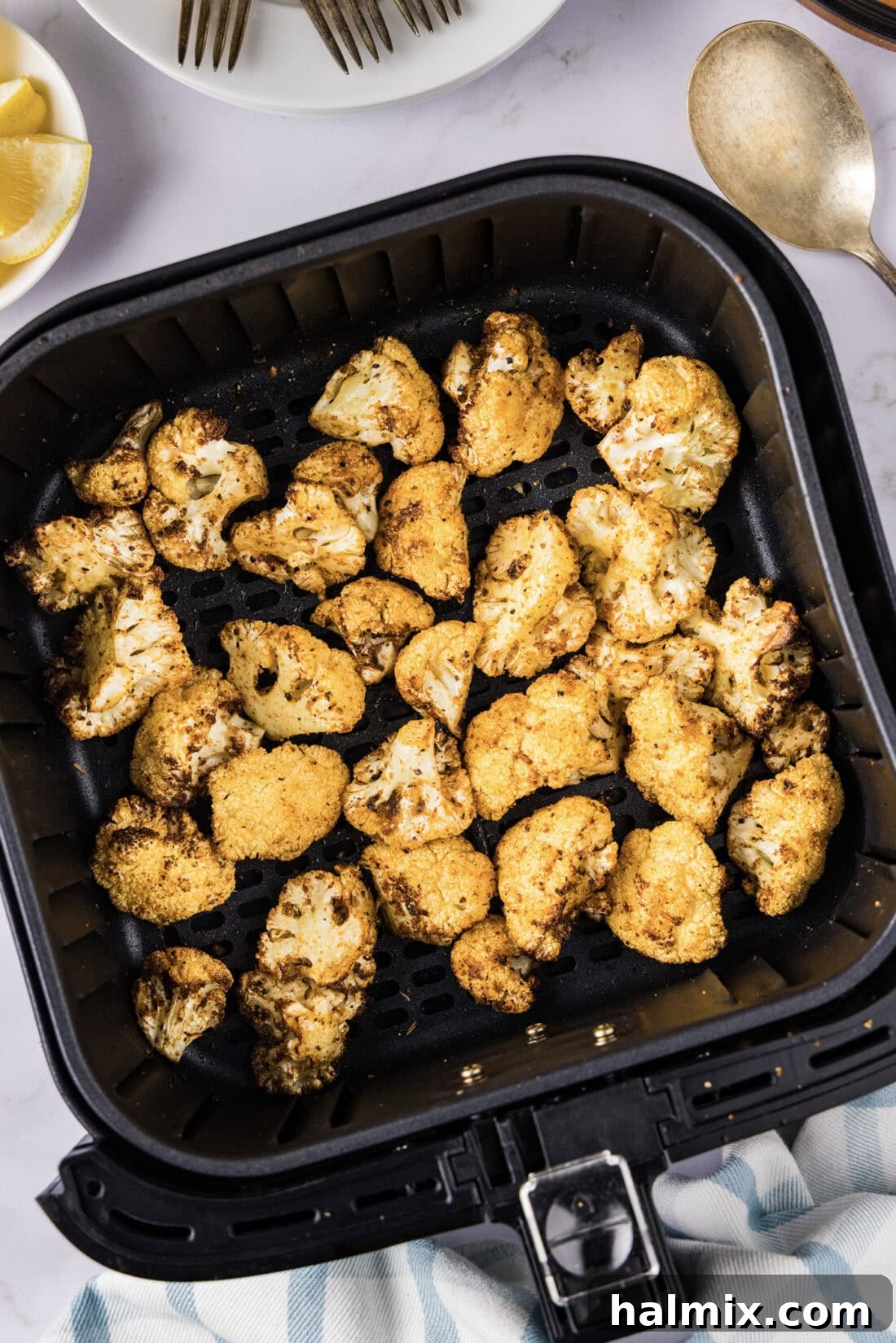 Golden Crispy Air Fryer Cauliflower 2 Air Fryer Cauliflower resting in an air fryer basket