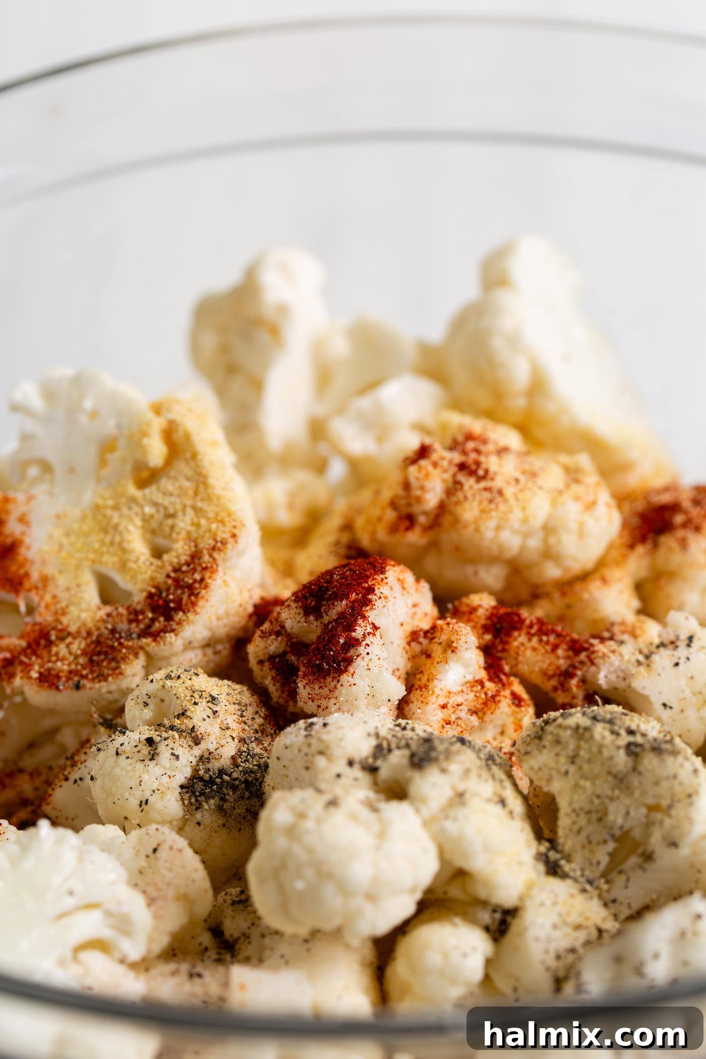 Golden Crispy Air Fryer Cauliflower 6 Seasonings sprinkled over a bowl of cauliflower