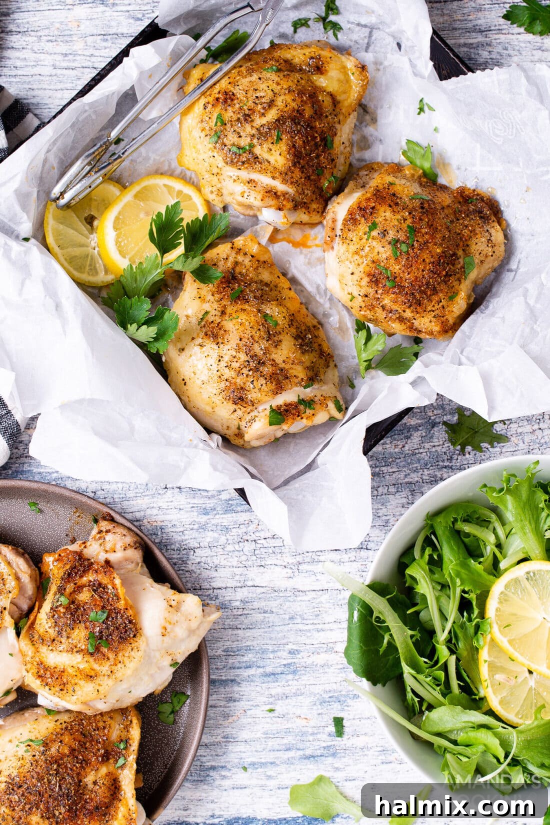 Golden Crispy Air Fryer Thighs 3 air fryer chicken thighs served in a square dish with a fresh green salad on the side