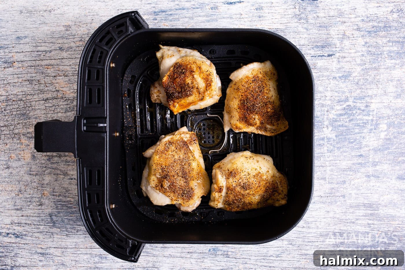 Golden Crispy Air Fryer Thighs 8 crispy air fryer chicken thighs, golden brown and perfectly cooked, shown in the air fryer basket