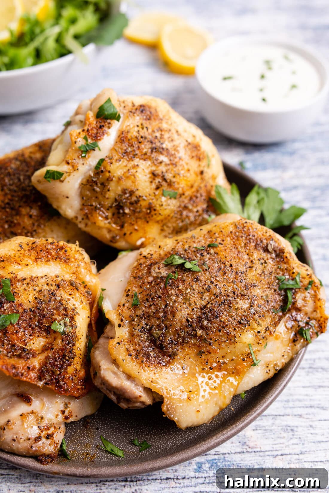 Golden Crispy Air Fryer Thighs 9 a beautifully plated air fried chicken thigh garnished with fresh parsley on a simple white plate